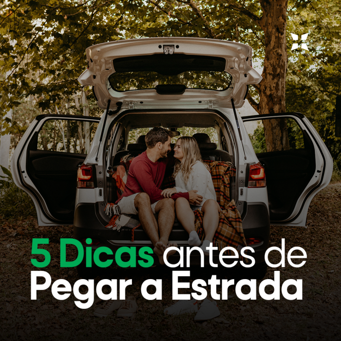 Casal (homem e mulher) sentados no Porta-malas de um veículo (categoria de veículos: minivan) branco estacionada entre árvores com o texto 5 dicas antes de pegar a estrada